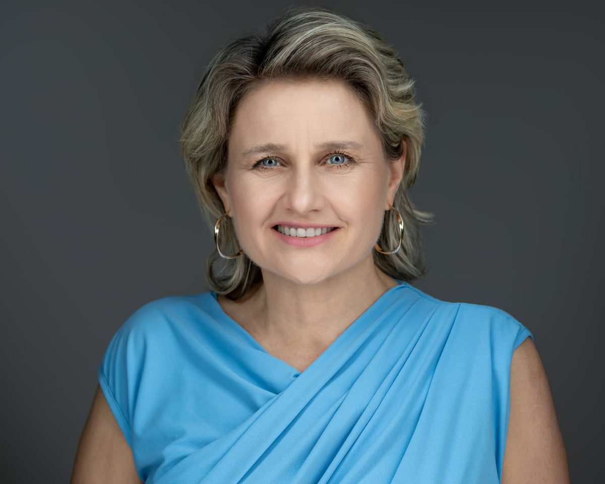 Langmár Zsuzsanna üzleti kommunikációs szakértő portréja kék ruhában